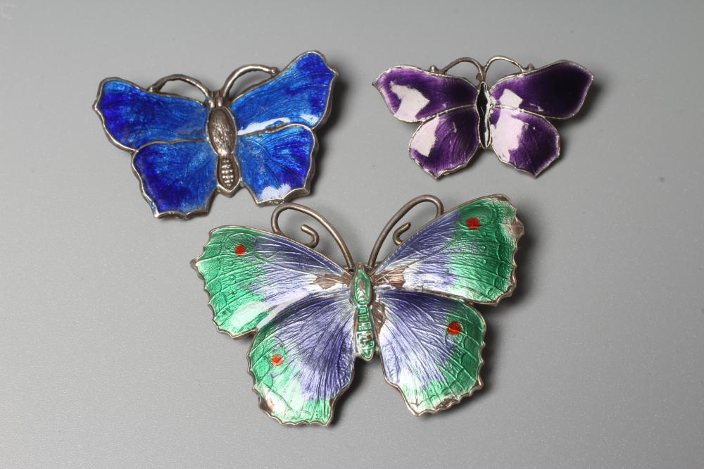 THREE SILVER AND ENAMEL BUTTERFLY BROOCHES comprising one with lilac and green wings, 1 3/4" span, a Image