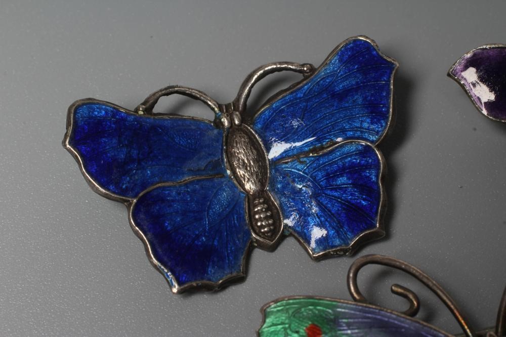 THREE SILVER AND ENAMEL BUTTERFLY BROOCHES comprising one with lilac and green wings, 1 3/4" span, a Image