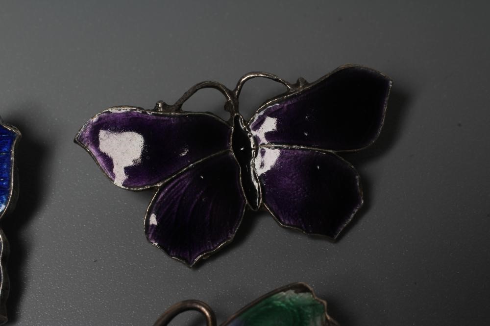 THREE SILVER AND ENAMEL BUTTERFLY BROOCHES comprising one with lilac and green wings, 1 3/4" span, a Image