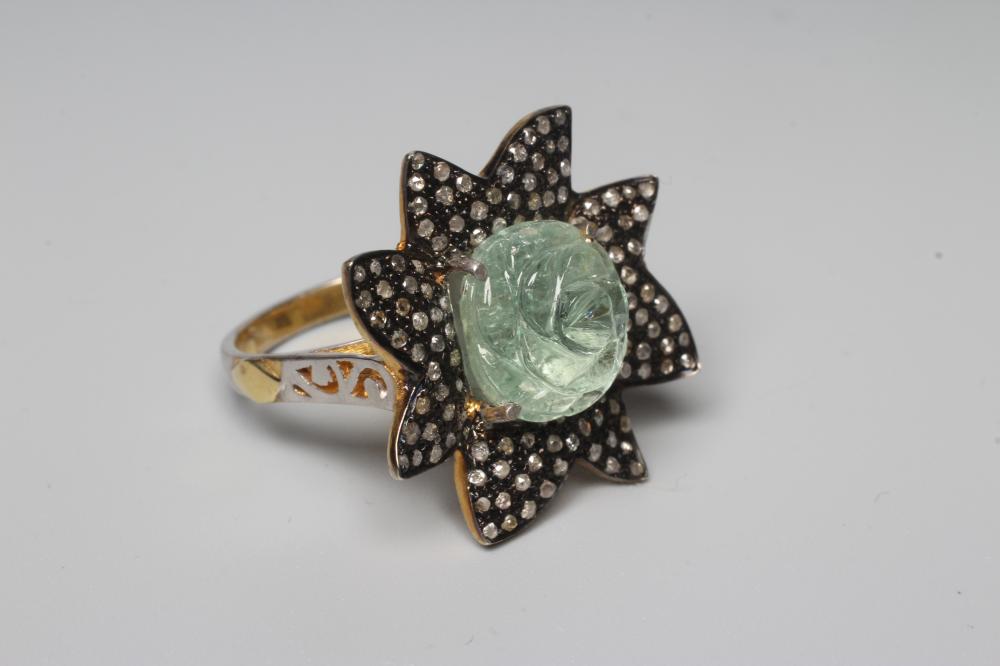 A DRESS RING centred by a rose carved aquamarine within a petal border pave set with small rose cut Image