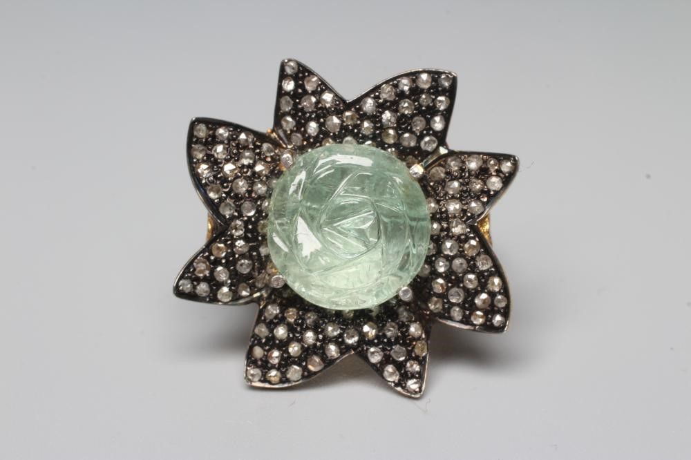 A DRESS RING centred by a rose carved aquamarine within a petal border pave set with small rose cut Image