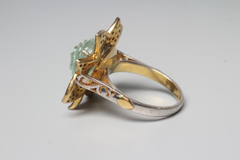 A DRESS RING centred by a rose carved aquamarine within a petal border pave set with small rose cut Image