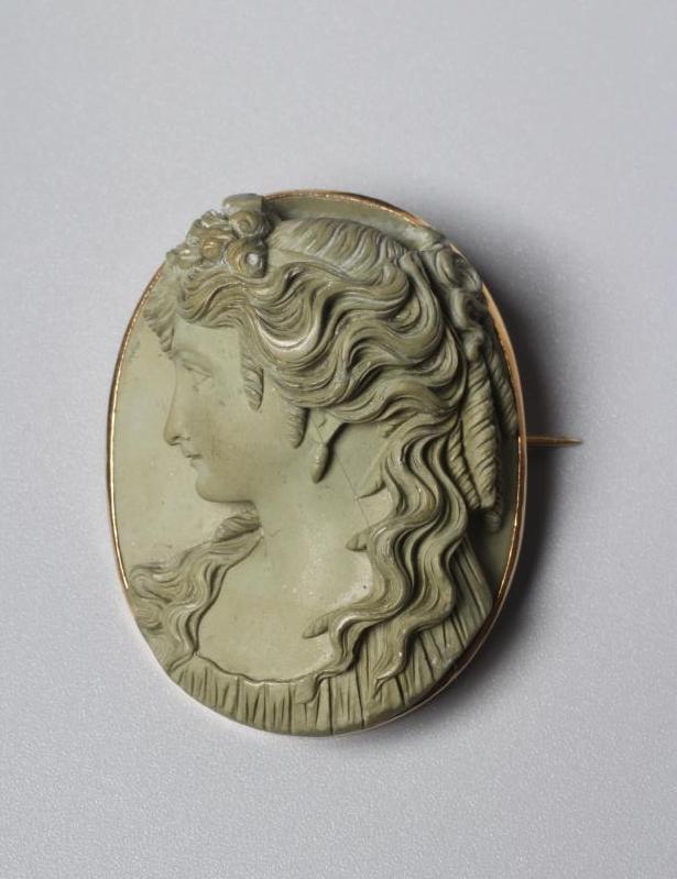 A VICTORIAN OVAL LAVA BROOCH carved in high relief with the head and shoulders portrait of the Greek Image
