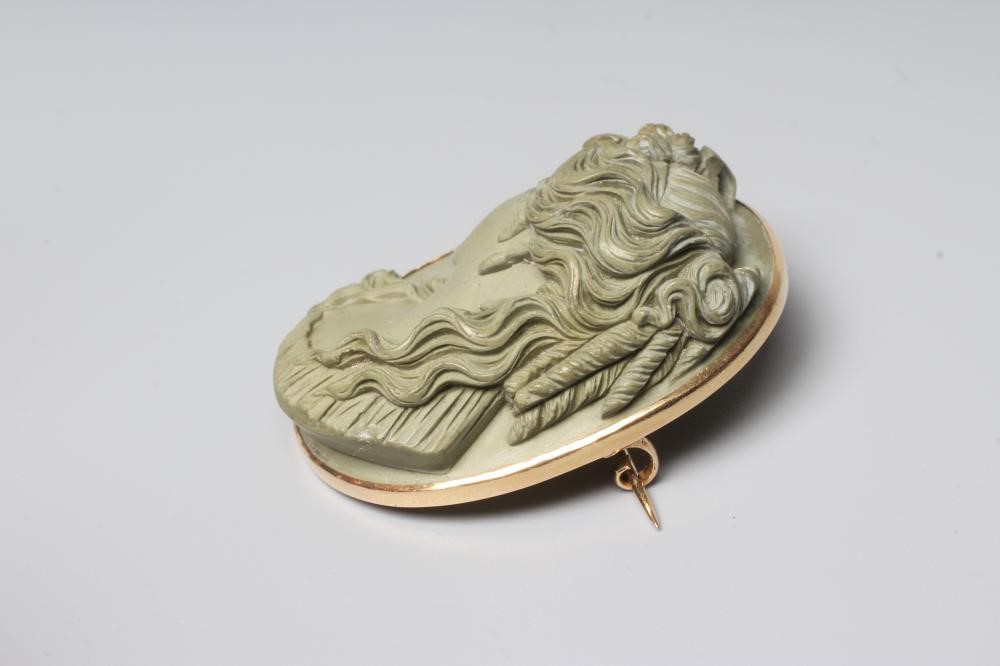 A VICTORIAN OVAL LAVA BROOCH carved in high relief with the head and shoulders portrait of the Greek Image