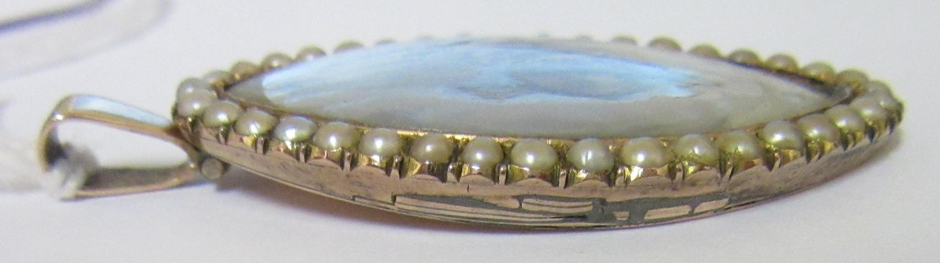 A GEORGIAN PENDANT inset with an eliptical ivory portrait miniature painted with the bust portrait Image