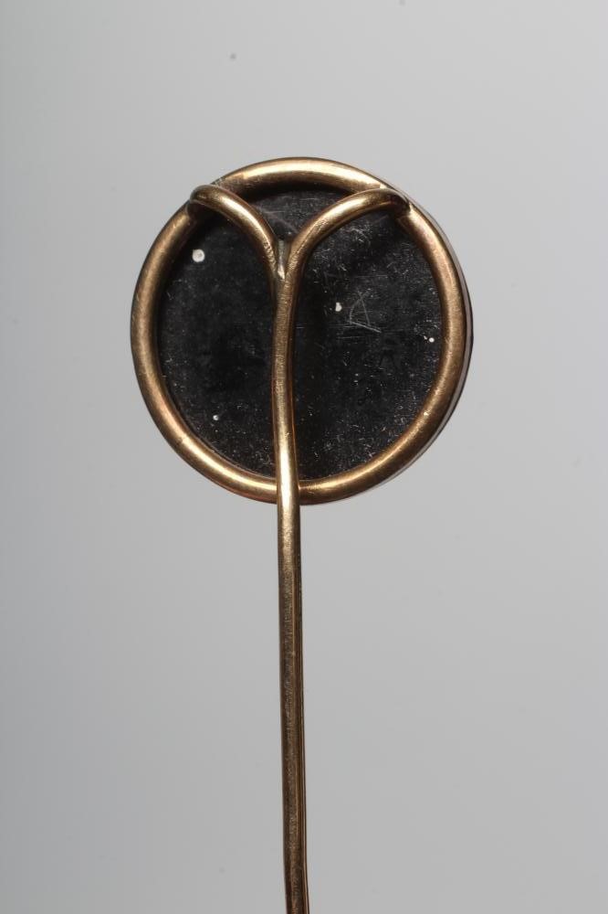 AN EARLY VICTORIAN STOCK PIN, the circular black and white agate panel cameo cut with a race horse Image