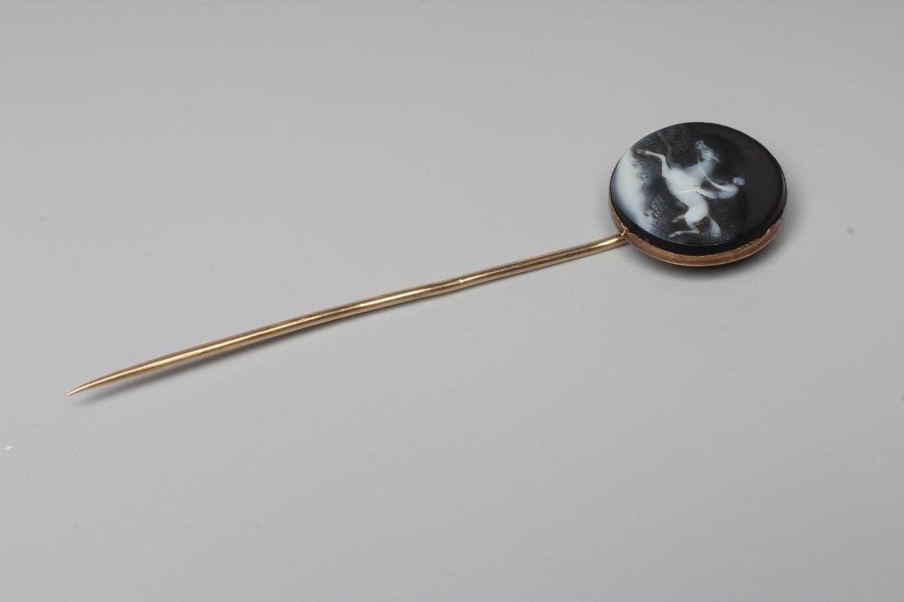 AN EARLY VICTORIAN STOCK PIN, the circular black and white agate panel cameo cut with a race horse Image