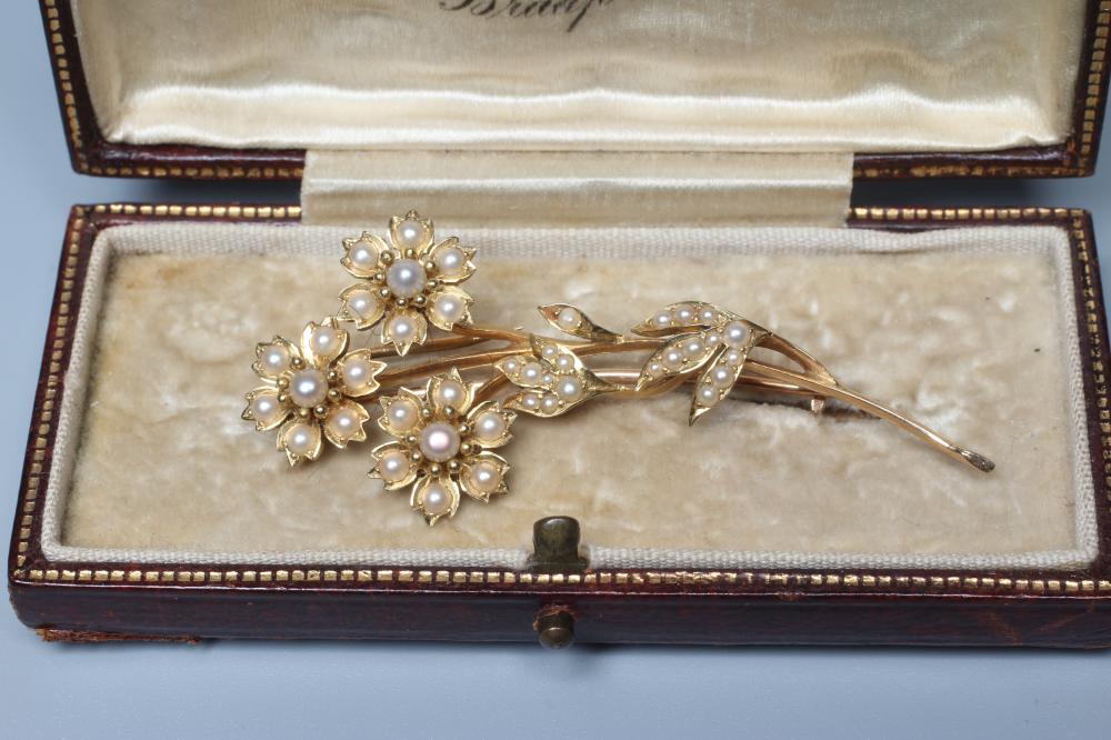 AN EDWARDIAN SEED PEARL SPRAY BROOCH, the three flower heads and leaves inset with numerous seed Image