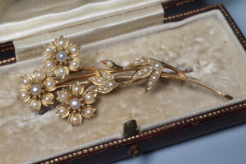 AN EDWARDIAN SEED PEARL SPRAY BROOCH, the three flower heads and leaves inset with numerous seed Image