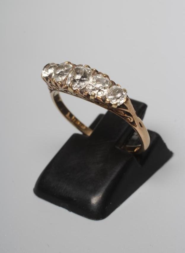A FIVE STONE DIAMOND RING, the graduated old cut stones set to carved shoulders and a plain shank Image