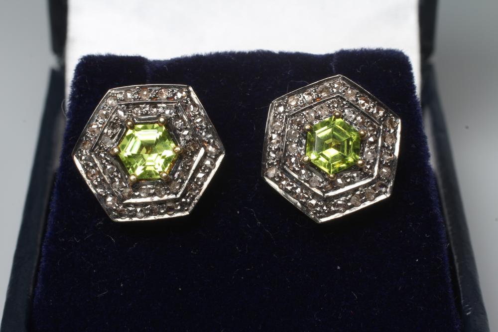 A PAIR OF PERIDOT AND DIAMOND EAR STUDS, the hexagonal cut peridots claw set to two rows of rose cut Image
