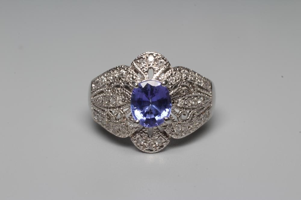 A TANZANITE AND DIAMOND COCKTAIL RING, the oval tanzanite claw set to borders pierced and set with Image