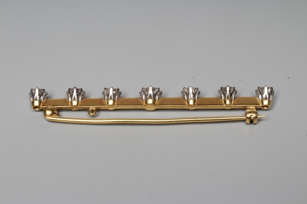 A SEVEN STONE DIAMOND BAR BROOCH, the central brilliant cut stone of approximately 0.75cts flanked Image