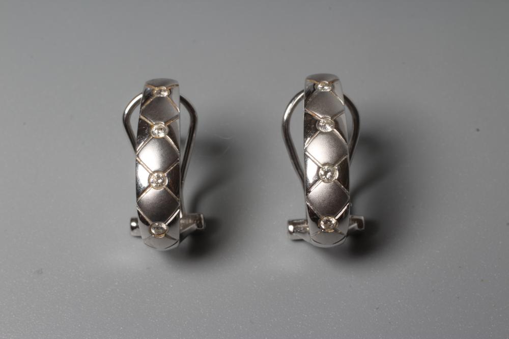 A PAIR OF DIAMOND EARRINGS, the matt and polished hexagonal engraved half loops each inset with Image