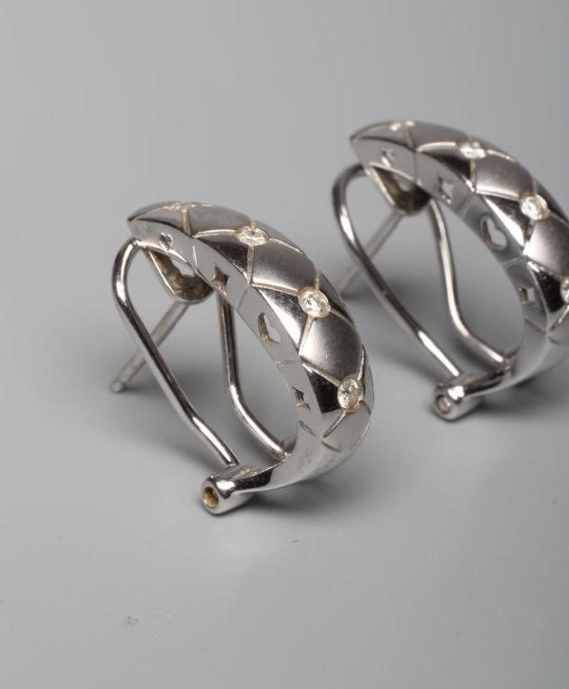 A PAIR OF DIAMOND EARRINGS, the matt and polished hexagonal engraved half loops each inset with Image