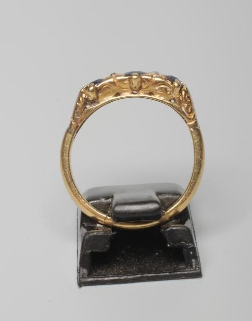 A SAPPHIRE AND DIAMOND HALF HOOP RING set with three facet cut sapphires with diamond points between Image