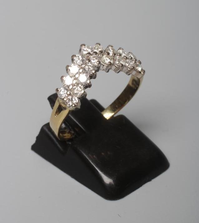 A DIAMOND WISHBONE RING claw set with nine pairs of round brilliant cut stones to a plain 18ct gold Image