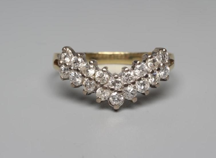 A DIAMOND WISHBONE RING claw set with nine pairs of round brilliant cut stones to a plain 18ct gold Image