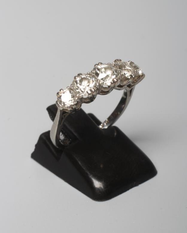 A FIVE STONE DIAMOND RING, the central brilliant cut stone of approximately 0.5cts flanked by four Image