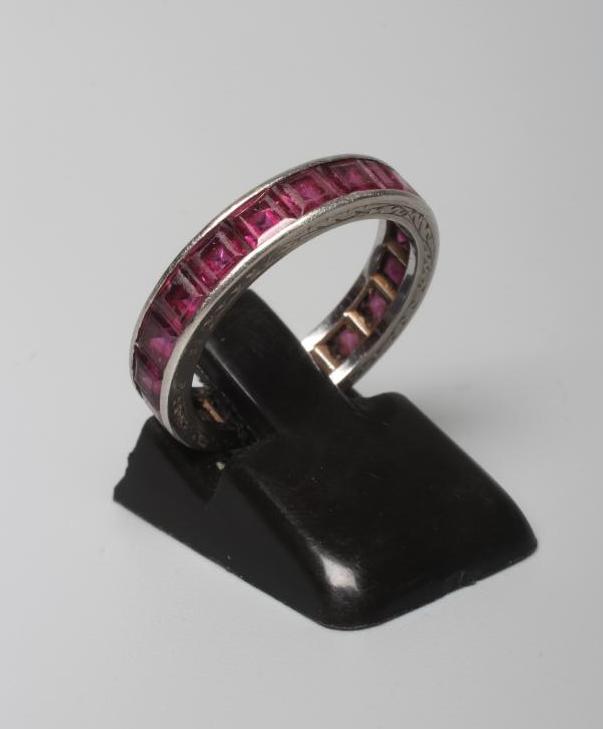 A RUBY ETERNITY RING, the calibre cut stones channel set to a foliate engraved platinum shank, Image
