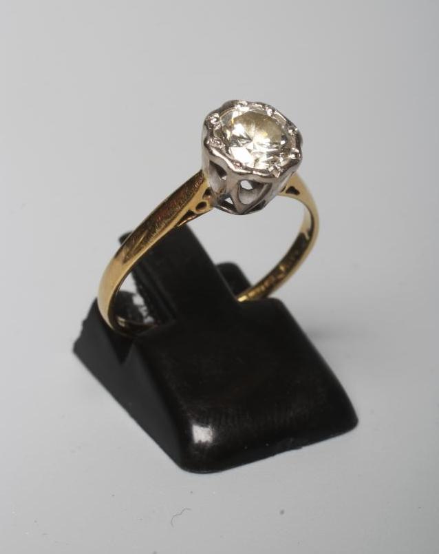 A SOLITAIRE DIAMOND RING, the brilliant cut stone of 1.03cts illusion set to a plain 18ct gold Image