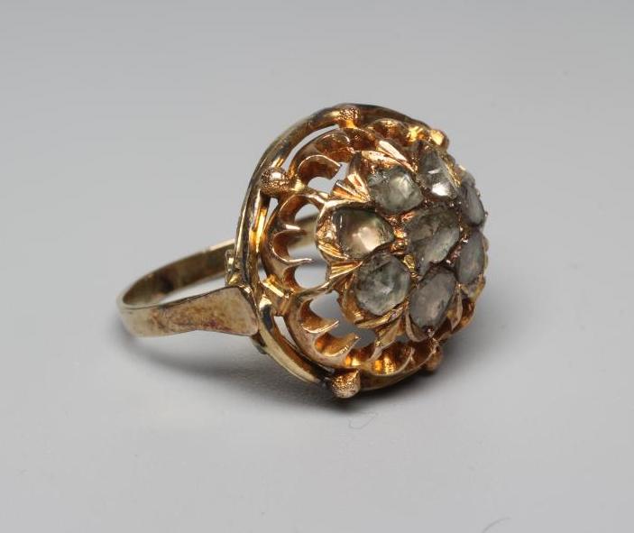 A DIAMOND DRESS RING, centrally set with eight mixed rose cut stones to an open frame and plain Image
