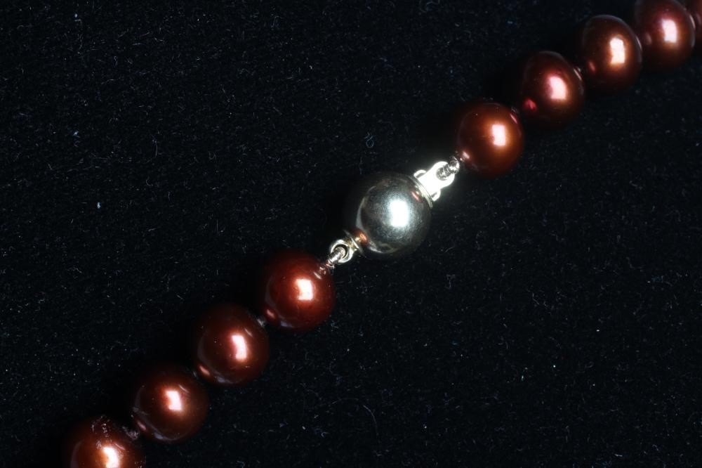 A SINGLE STRING OF CHOCOLATE FRESHWATER PEARLS strung to a ball clasp stamped 375 Image