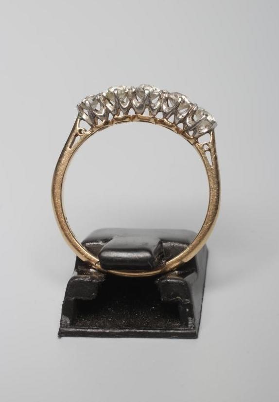 A FIVE STONE DIAMOND RING, the graduating brilliant cut stones claw set to a plain shank, stamped Image