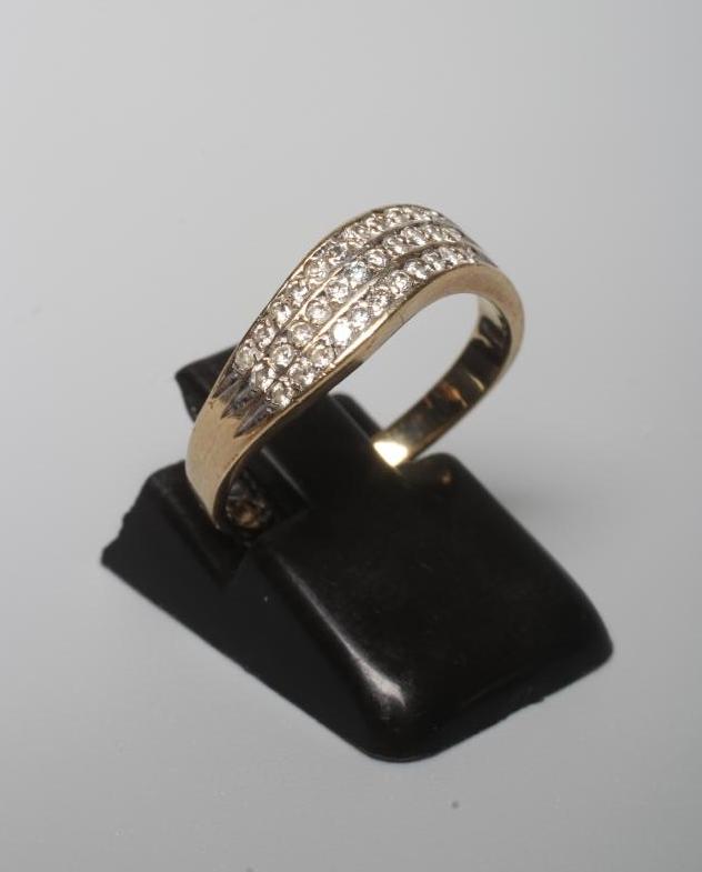 A DIAMOND DRESS RING, the wavy band point set with three bands of eleven stones to a plain shank Image