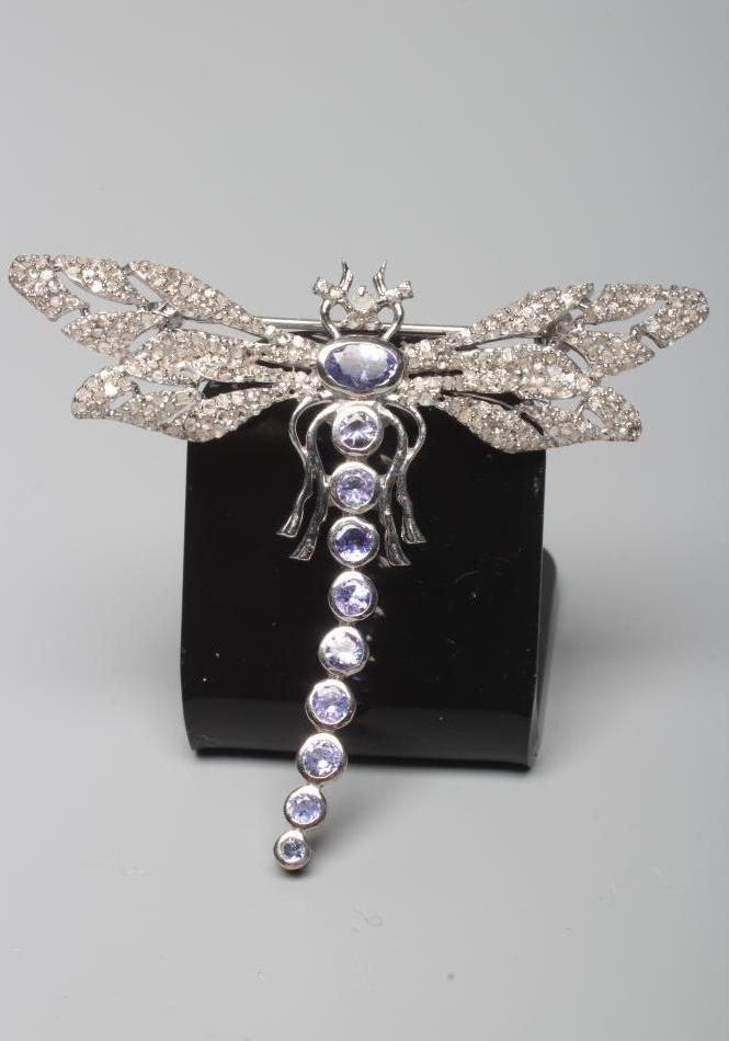 A TANZANITE AND DIAMOND DRAGONFLY BROOCH, the body and head set with graduating oval cut tanzanite Image