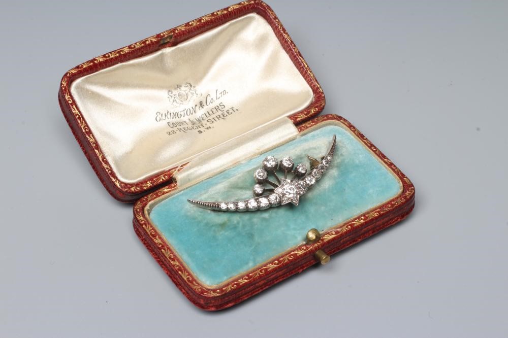 A DIAMOND CRESCENT BROOCH centred by a small star with a point set brilliant cut stone of Image