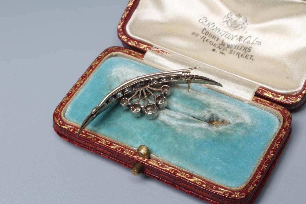 A DIAMOND CRESCENT BROOCH centred by a small star with a point set brilliant cut stone of Image