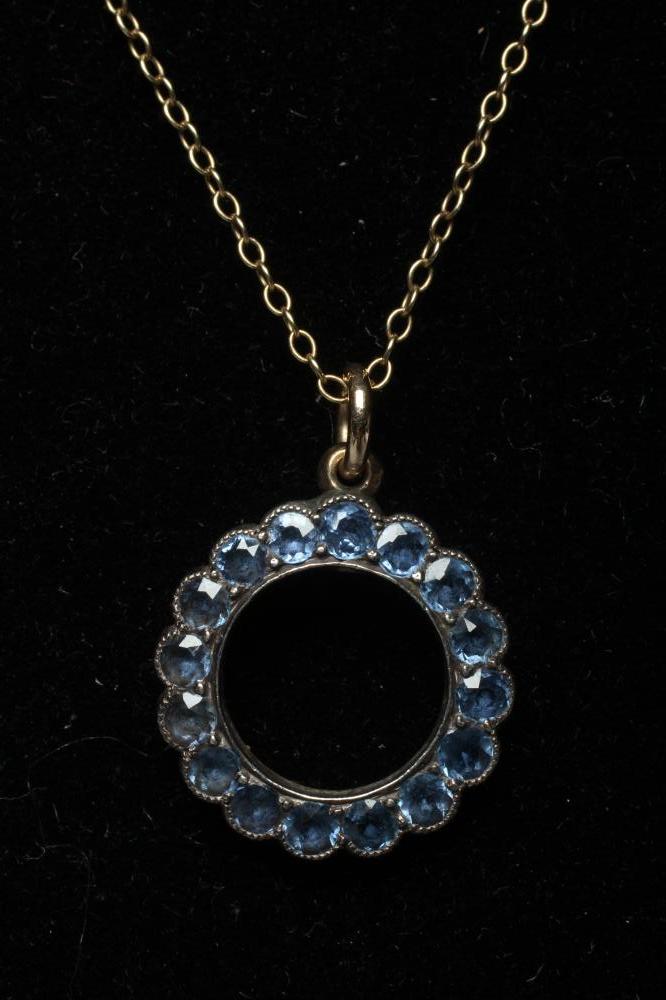 A SAPPHIRE CIRCLET PENDANT, the small facet cut stones in rub over settings to an unmarked plain Image