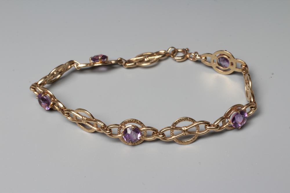 AN AMETHYST BRACELET, the 9ct gold snaffle links claw set with five round facet cut stones, Image