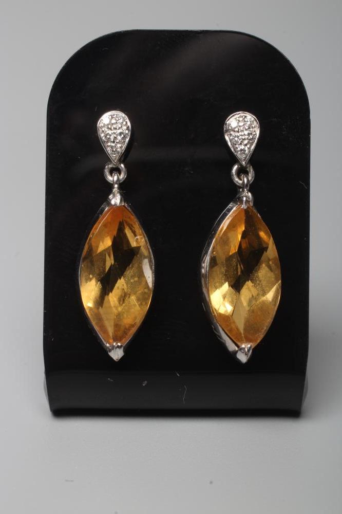 A PAIR OF CITRINE DROP EAR STUDS, the marquise cut stones collet set to a plain white unmarked frame Image