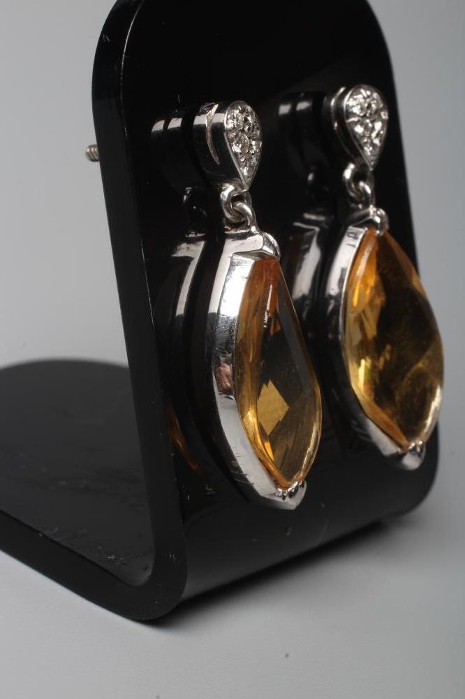 A PAIR OF CITRINE DROP EAR STUDS, the marquise cut stones collet set to a plain white unmarked frame Image