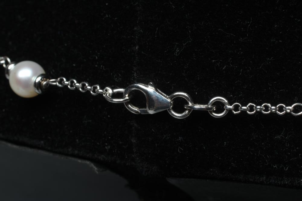 A WHITE CHAIN NECKLACE with twenty cultured pearl spacers to a lobster clasp, stamped 750 Image