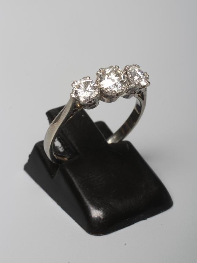 A THREE STONE DIAMOND RING, the central stone of approximately 0.40cts, all claw set to a plain Image