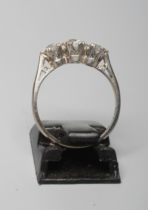 A THREE STONE DIAMOND RING, the central stone of approximately 0.40cts, all claw set to a plain Image