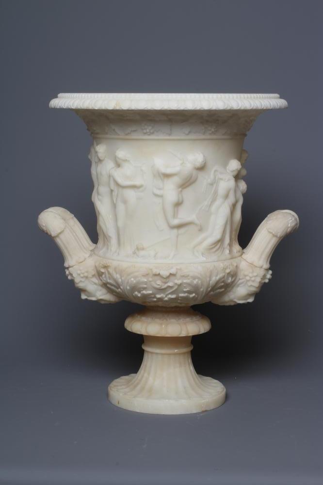 A CARVED ALABASTER URN - After the Antique, of campana form with ovolu rim, over a frieze of Image
