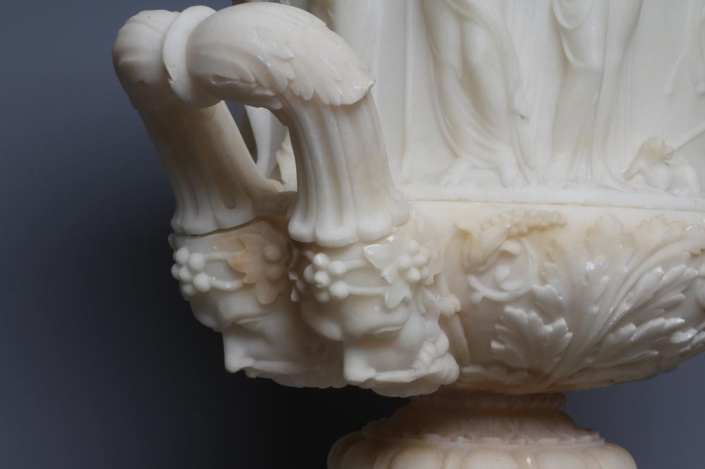 A CARVED ALABASTER URN - After the Antique, of campana form with ovolu rim, over a frieze of Image