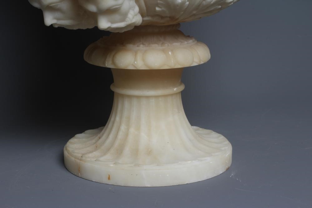 A CARVED ALABASTER URN - After the Antique, of campana form with ovolu rim, over a frieze of Image