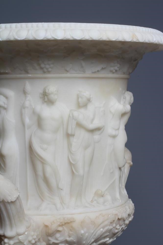 A CARVED ALABASTER URN - After the Antique, of campana form with ovolu rim, over a frieze of Image