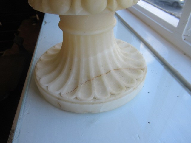A CARVED ALABASTER URN - After the Antique, of campana form with ovolu rim, over a frieze of Image