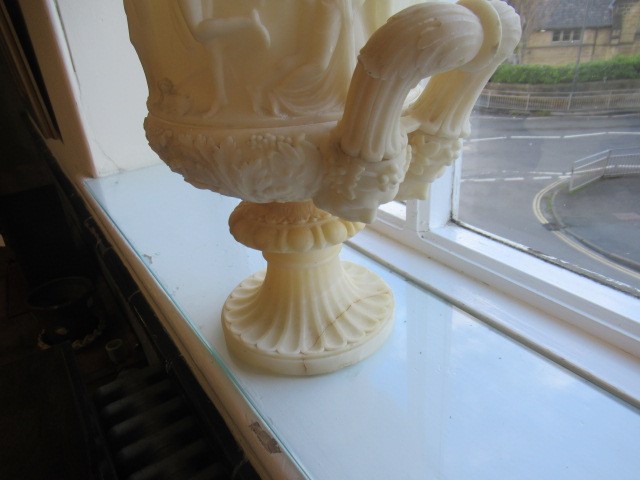 A CARVED ALABASTER URN - After the Antique, of campana form with ovolu rim, over a frieze of Image