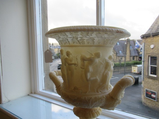 A CARVED ALABASTER URN - After the Antique, of campana form with ovolu rim, over a frieze of Image