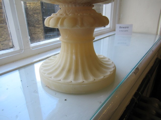 A CARVED ALABASTER URN - After the Antique, of campana form with ovolu rim, over a frieze of Image