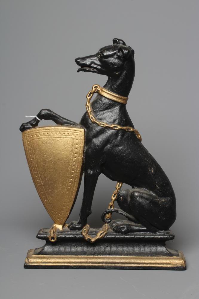 AN EDWARDIAN CAST IRON DOORSTOP of heraldic design with a lurcher holding a shield, painted in black Image
