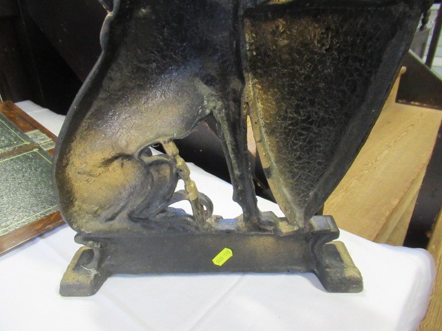 AN EDWARDIAN CAST IRON DOORSTOP of heraldic design with a lurcher holding a shield, painted in black Image