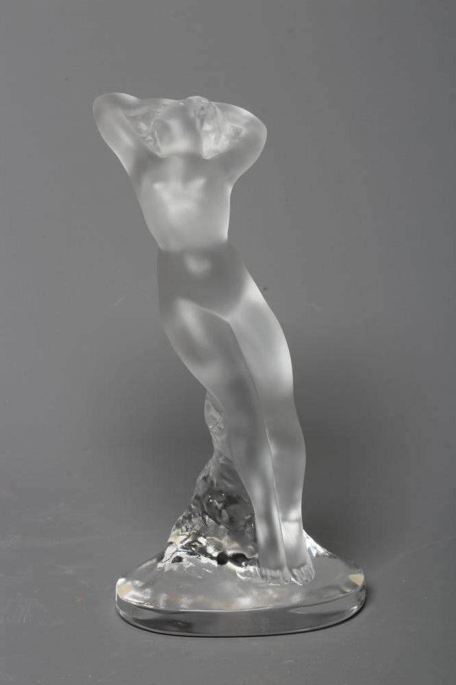 A LALIQUE "DANSEUSE BRAS LEVES", modern, the frosted nude figure leaning against a clear rocky Image